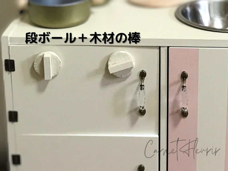 DIYキッチンに取り付けたクリアカラーの取っ手(Seria)と段ボールでつくったコンロのつまみ