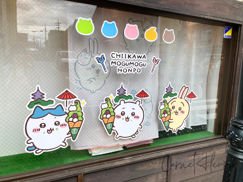 窓ガラスの外側には抹茶アイスを食べるちいかわ・ハチワレ・うさぎの絵が描かれている。