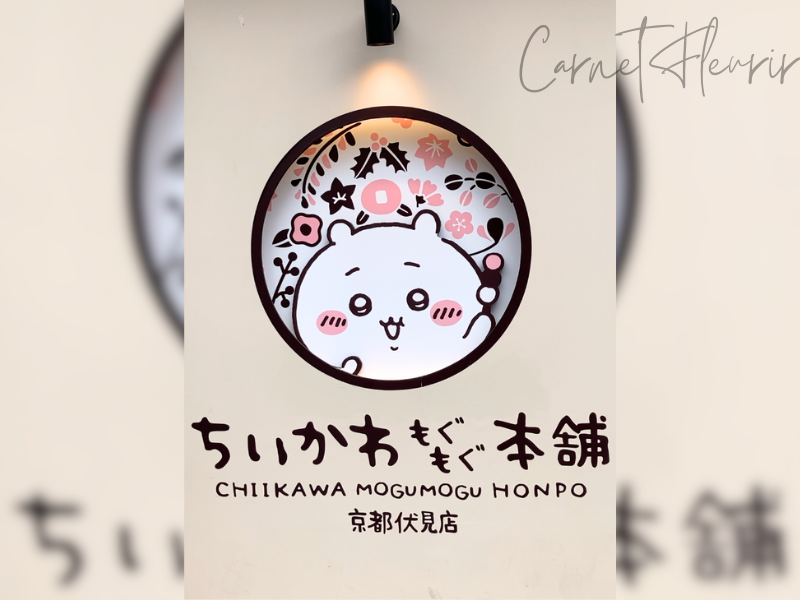 ちいかわもぐもぐ本舗の外装。店名の上にはちいかわが団子をもちながら覗いている様子。