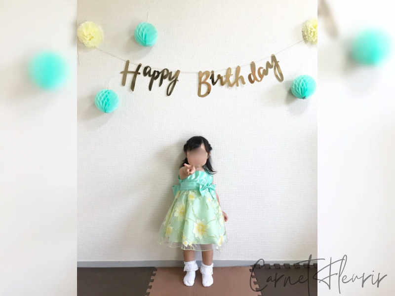 2歳の誕生日。ミントグリーンとイエローのドレスに合わせたシンプルな飾り付けの画像