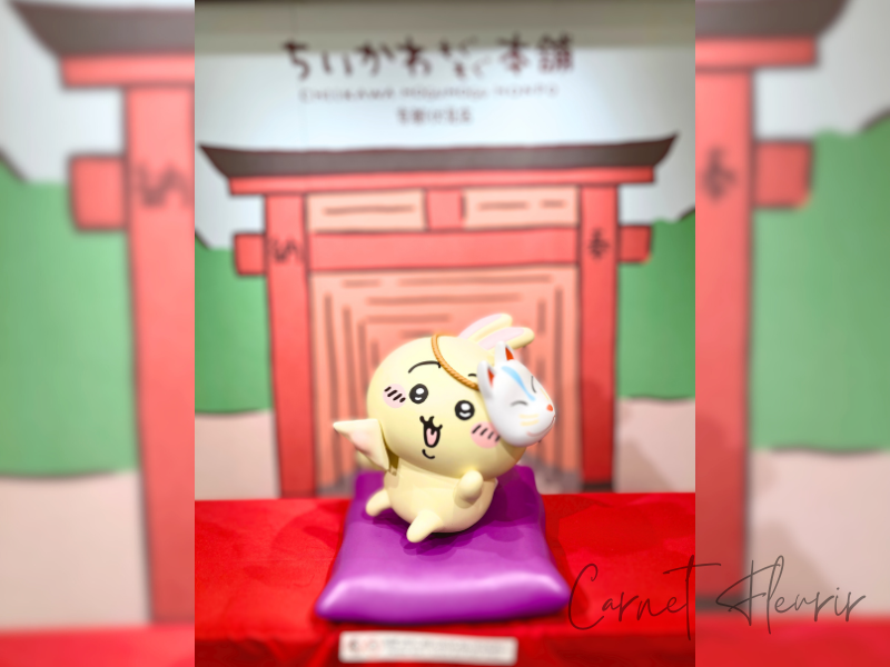 うさぎのフォトスポット。伏見稲荷の鳥居をモチーフとした絵の前で、生八ツ橋を食べている様子。