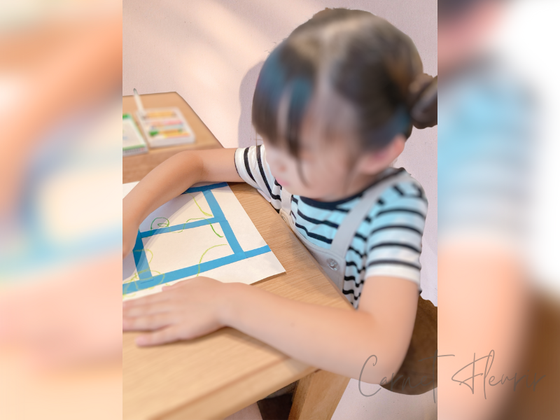 朝顔アートを制作中の子どもの様子。支柱の部分にツルをクレヨンで書いている
