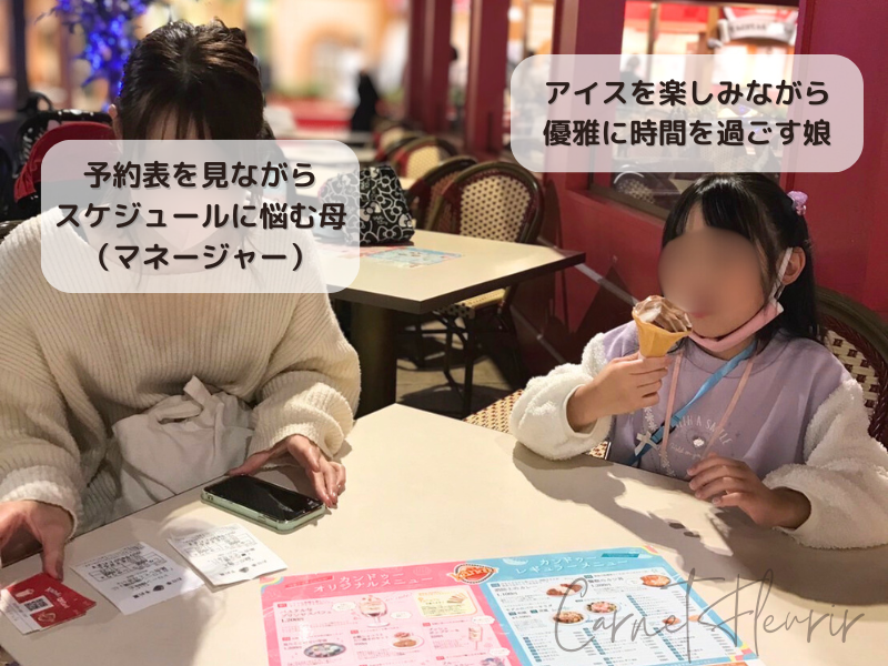 アイスを食べてのんびり過ごす娘と、予約表を見ながらスケジュール調整に悩む母