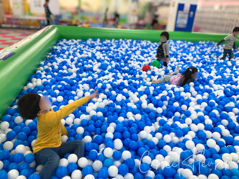 青と白のボールプールで遊ぶ子どもたちの様子。