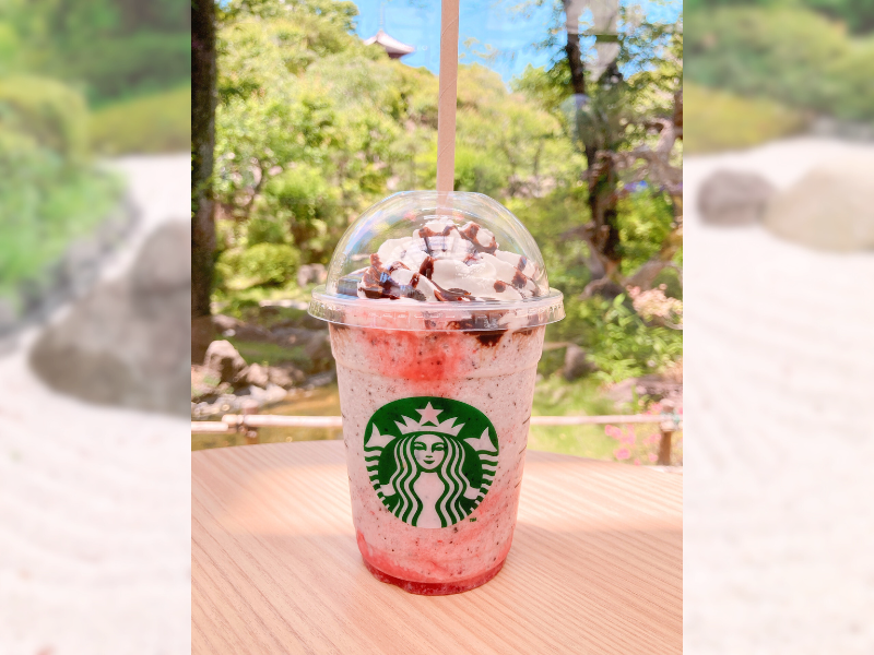 HANA・BIYORI内スタバのテーブルに置かれたドリンク、奥には日本庭園風の景色が広がる様子