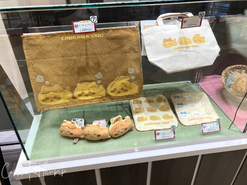 ちいかわ焼き限定のランチョンマットやミニタオル、ぬいぐるみ付きキーホルダーなどが並ぶショーケース