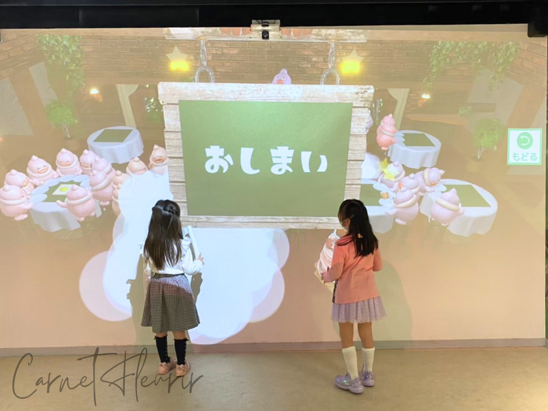 カンドゥーの『タッチ&ラーン』体験終了シーン|スクリーンに向かって立つ子どもたちと“おしまい”の画面