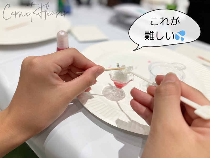 かき氷の器にレジンを盛り付ける様子。「これが難しい」の吹き出しつき