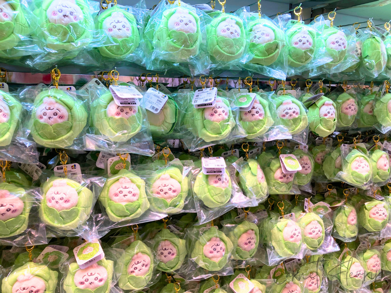 キャベツの葉っぱにくるまれたうさぎのぬいぐるみがぎっしりと並んでいる棚。カラフルで可愛い印象。