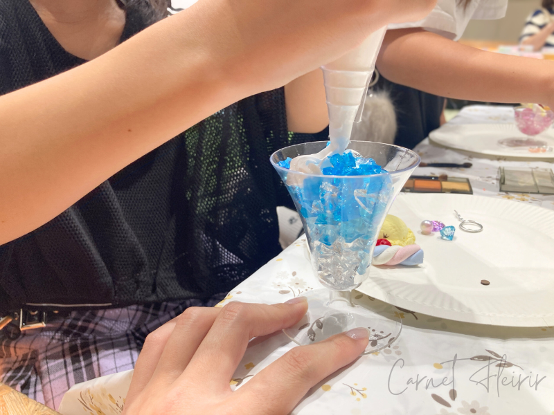 ジェルキャンドルの上にホイップ粘土を絞っている様子│パフェ風メモスタンドの仕上げ作業中