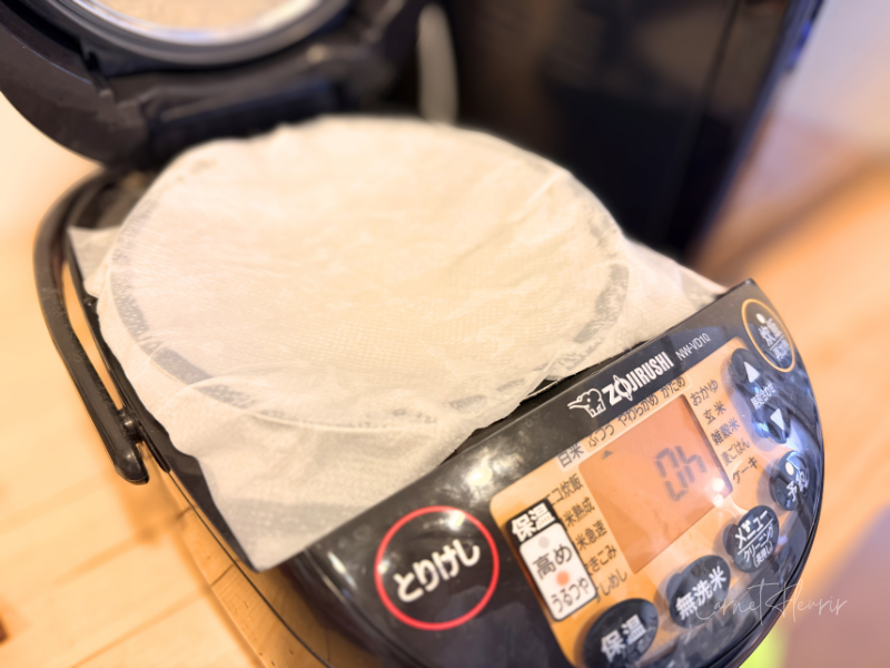 炊飯器に濡れ布巾をかけて保温をしている様子