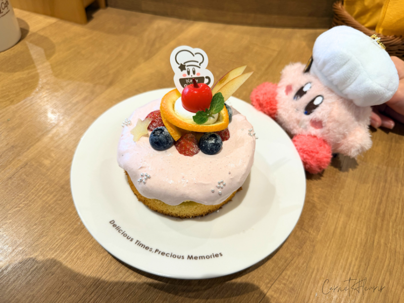 2026年4月の限定メニュー、カービィのバーズデーケーキ。購入したぬいぐるみとともに撮影。