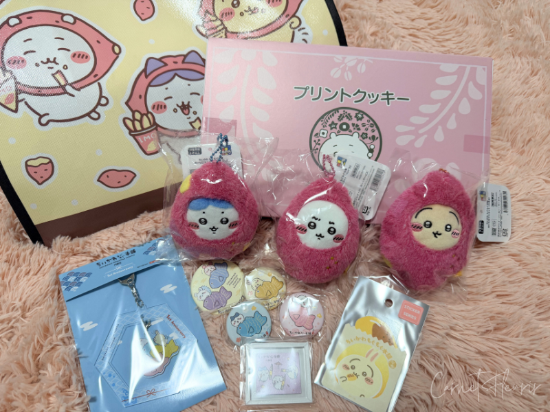 筆者の購入品。おいもなマスコット3種類と、缶バッジ・ステッカー・マグネット・クッキー。購入特典のノベルティも。