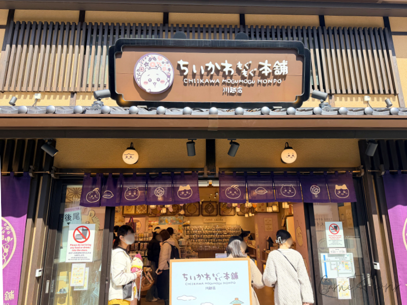 ちいかわもぐもぐ本舗の川越店、入口の外装。店名の横にはちいかわが団子をもっている様子。