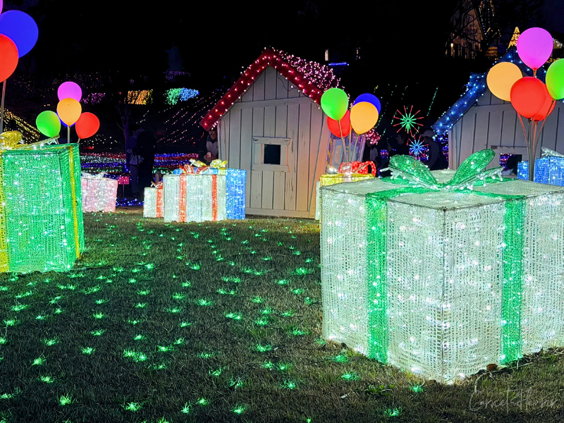 家やプレゼントボックスの形をしたイルミネーション。光る風船も配置されている。